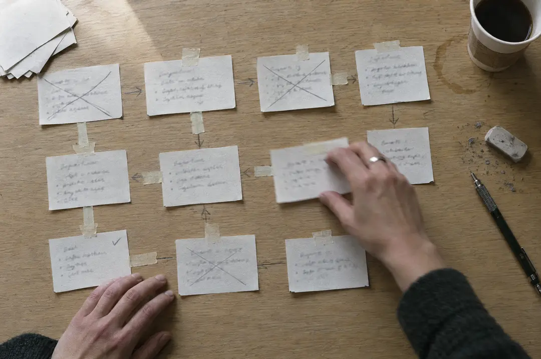 Hands arranging workflow cards